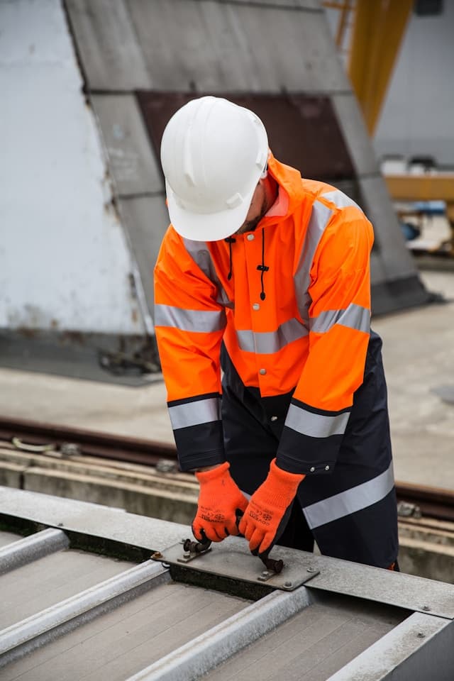 Worker in a high-visibility orange uniform jacket
