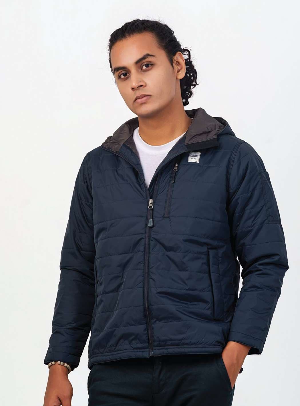 Model wearing a navy hooded quilted jacket