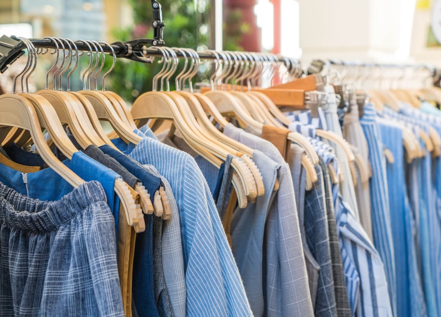 Blue and striped shirts on wooden hangers