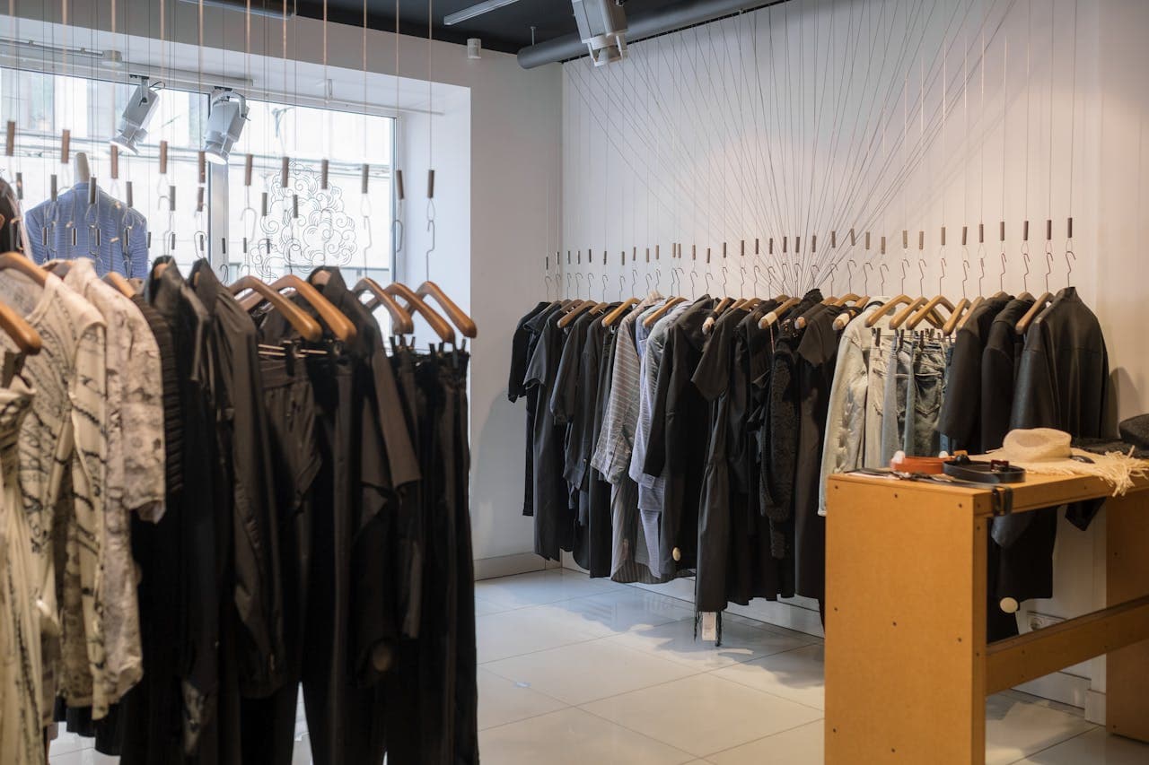 Pared-back boutique interior with garments on wall-mounted hangers