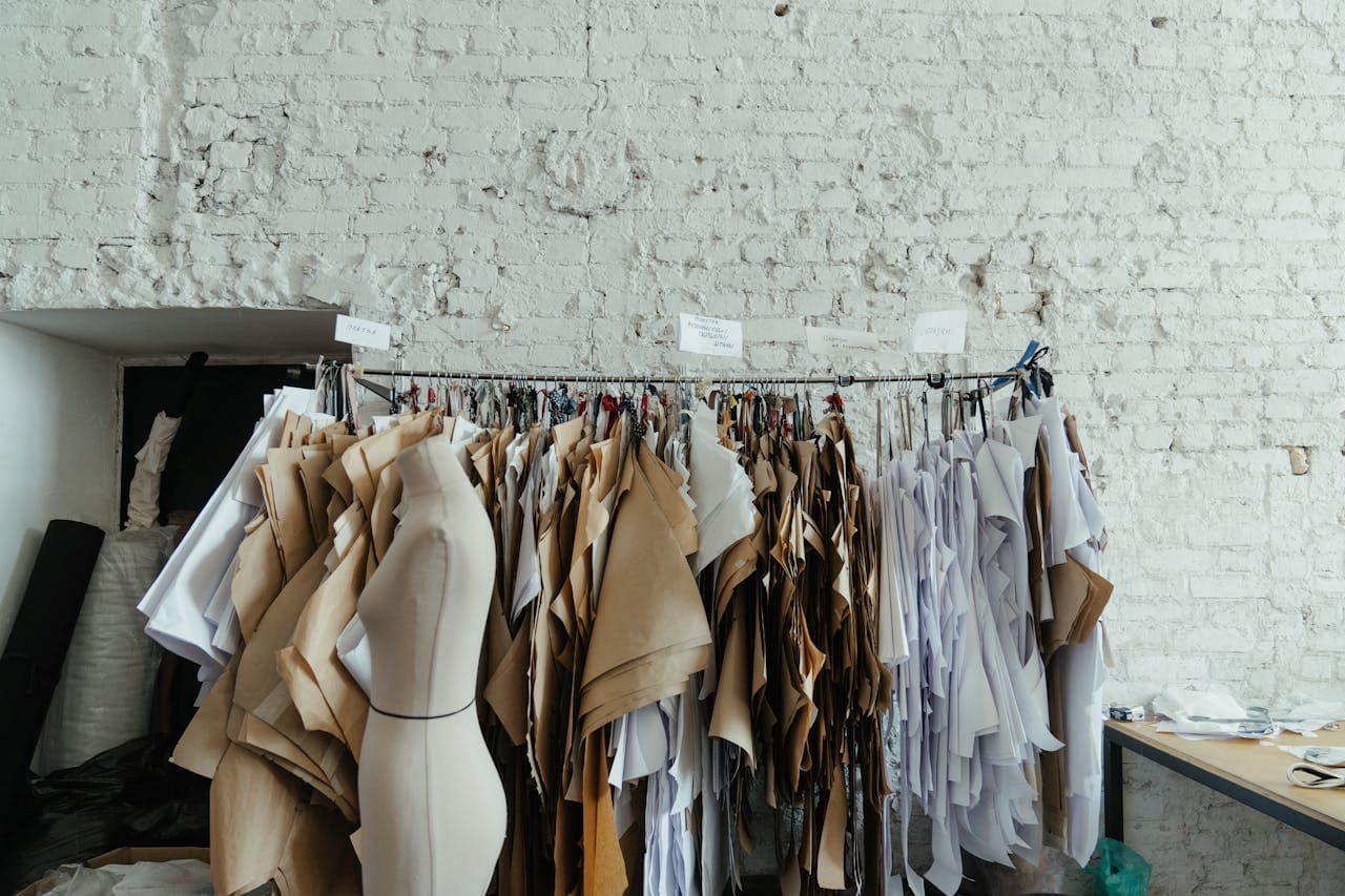 Paper and kraft pattern pieces hung on a rail beside a dress form