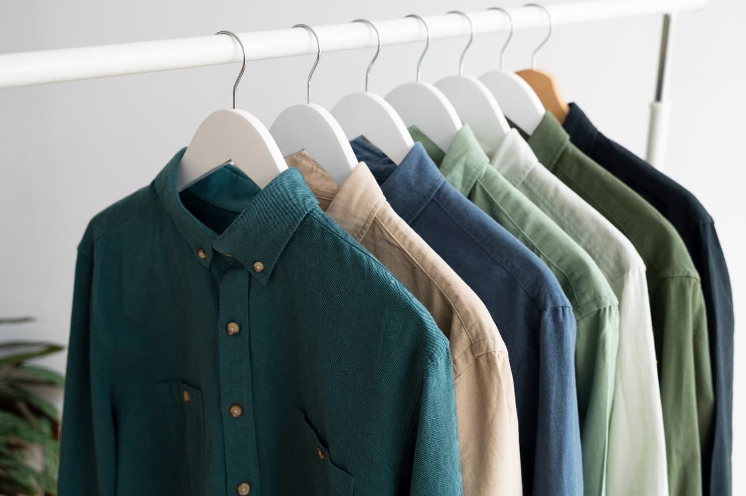 Row of cotton button-down shirts on white hangers