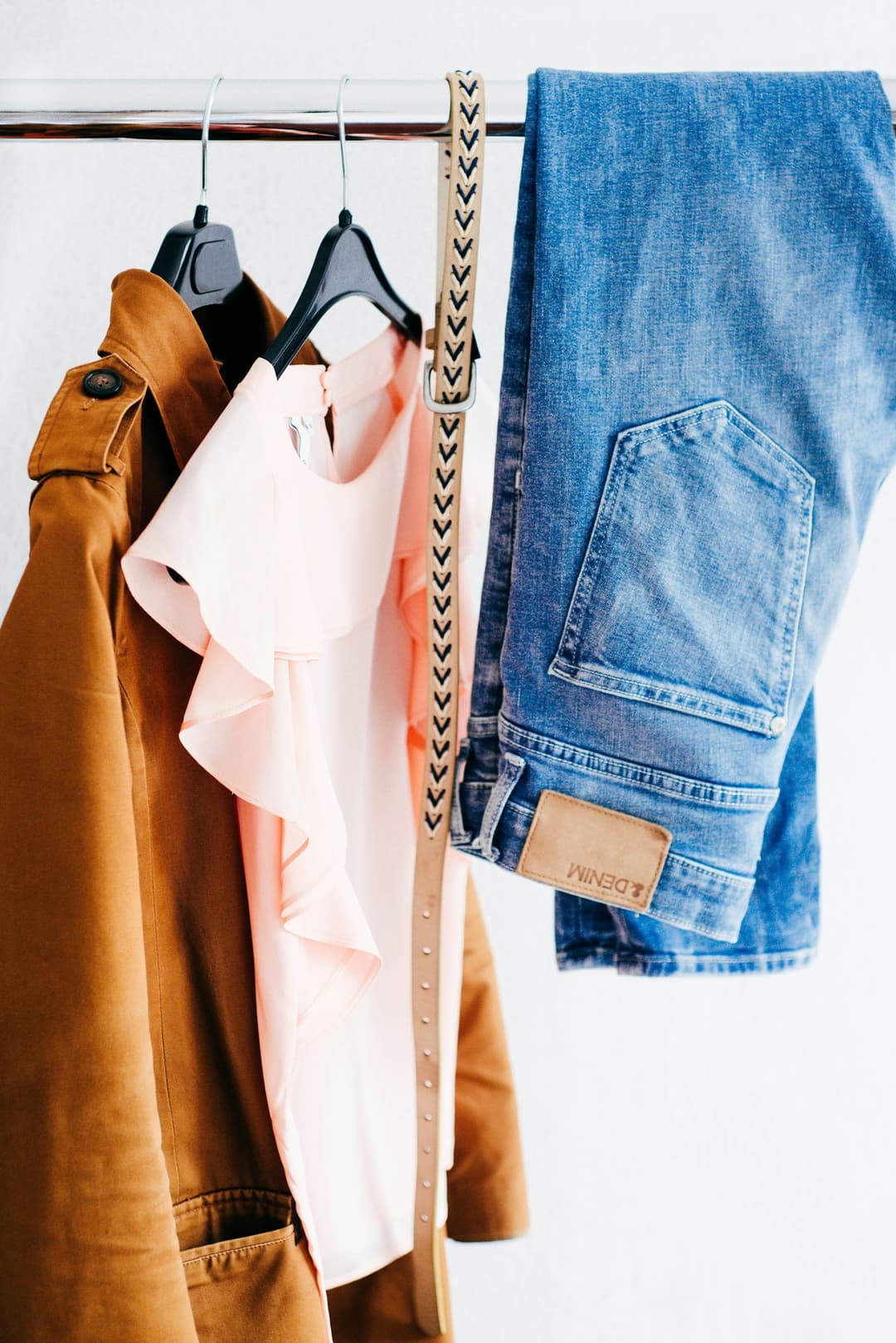 Jacket, blouse and denim styled together on a garment rail