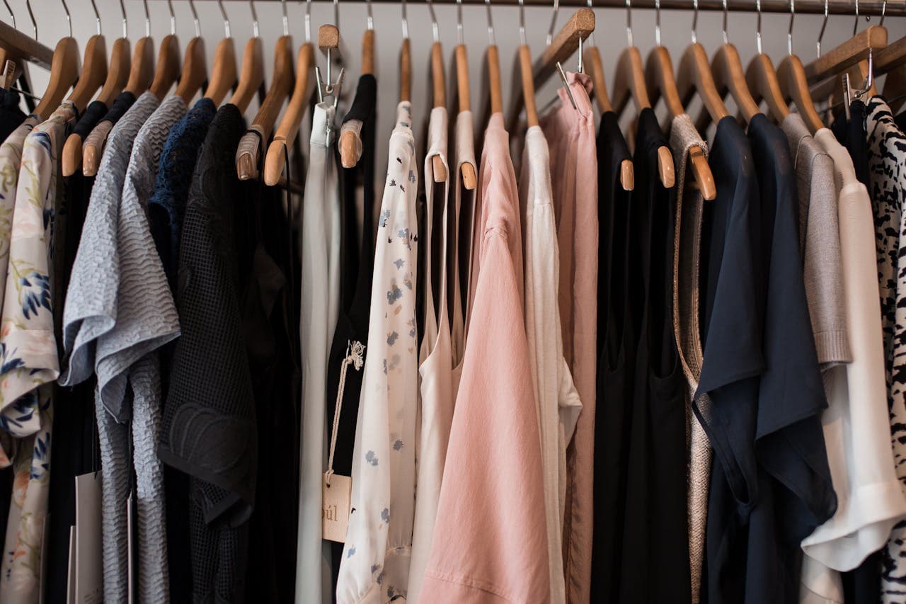 Womenswear in blush, black and cream on wooden hangers